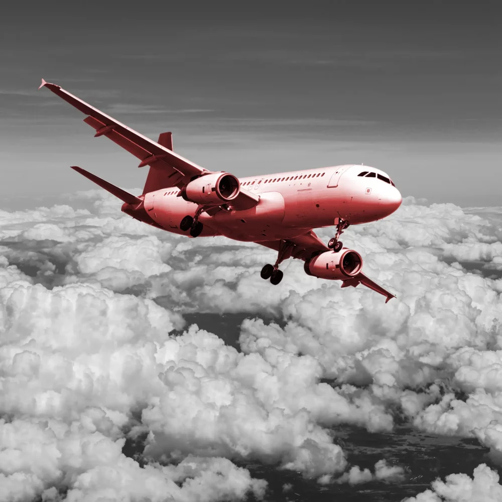 Commercial airplane flying above the clouds during daylight.