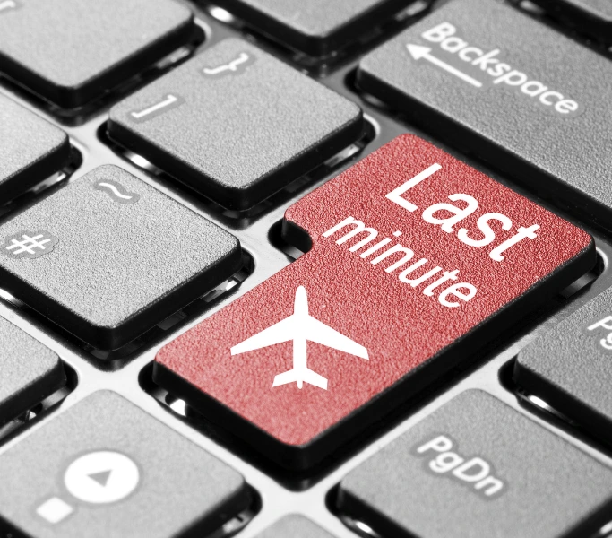 Red last-minute travel key on keyboard — urgent business travel booking solution
