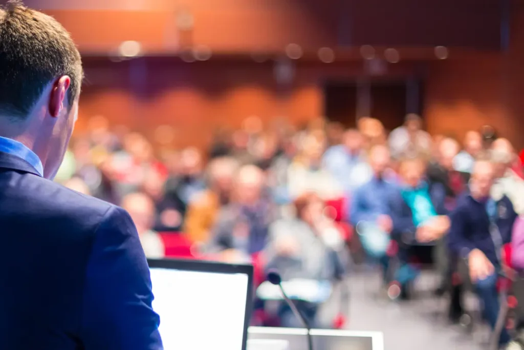 Business speaker addressing a corporate conference audience at a professional event in France