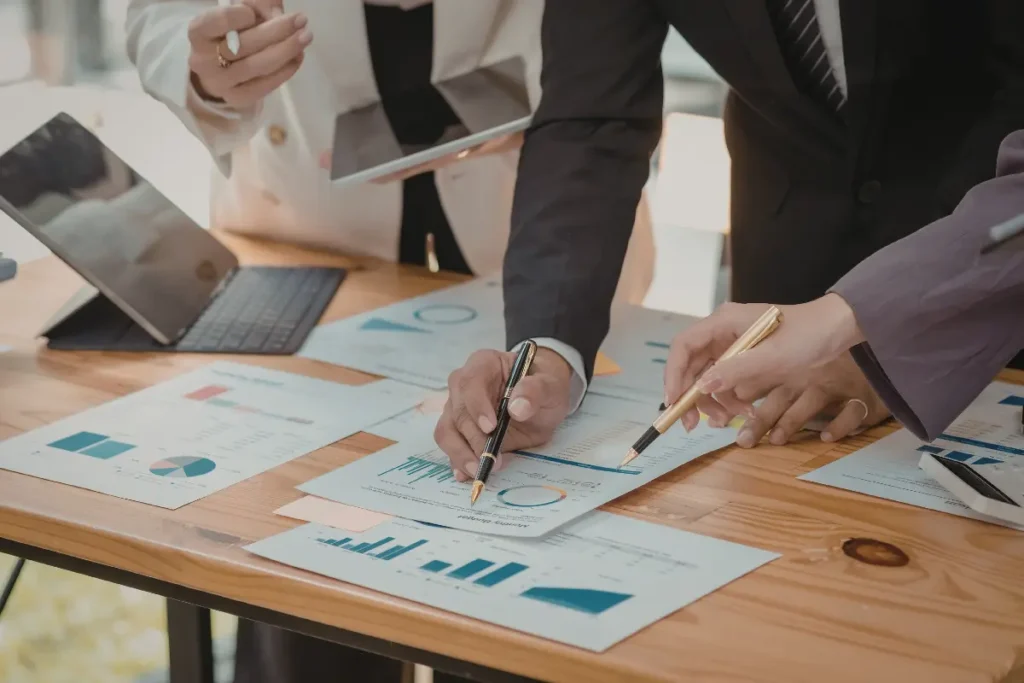 Corporate travel expense management review with executives analyzing financial reports and dashboards