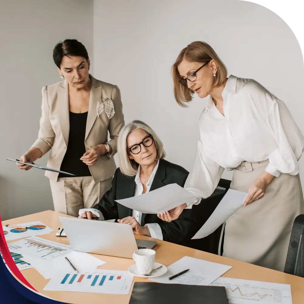 Finance team reviewing corporate travel expense reports and budget analytics on laptop in an office meeting