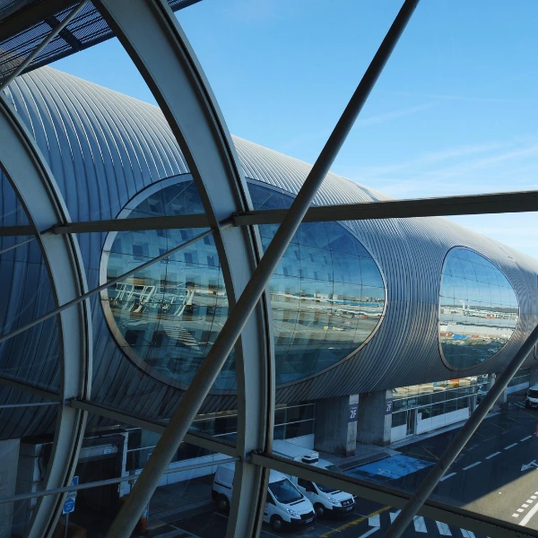Modern airport terminal architecture with glass structure and runway view_