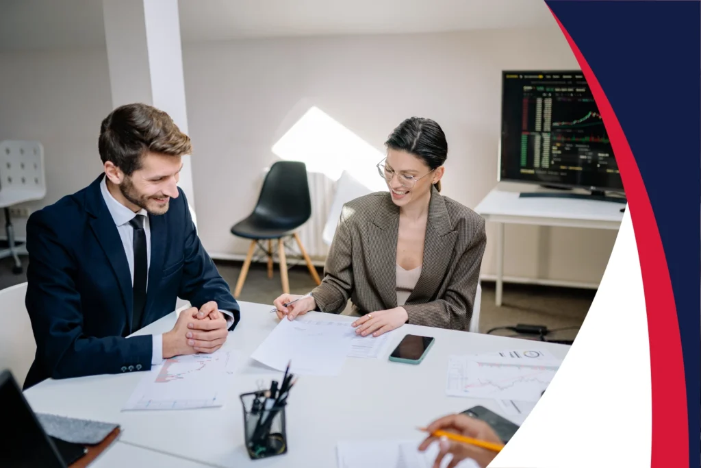 Business professionals reviewing financial documents and discussing strategy at office table