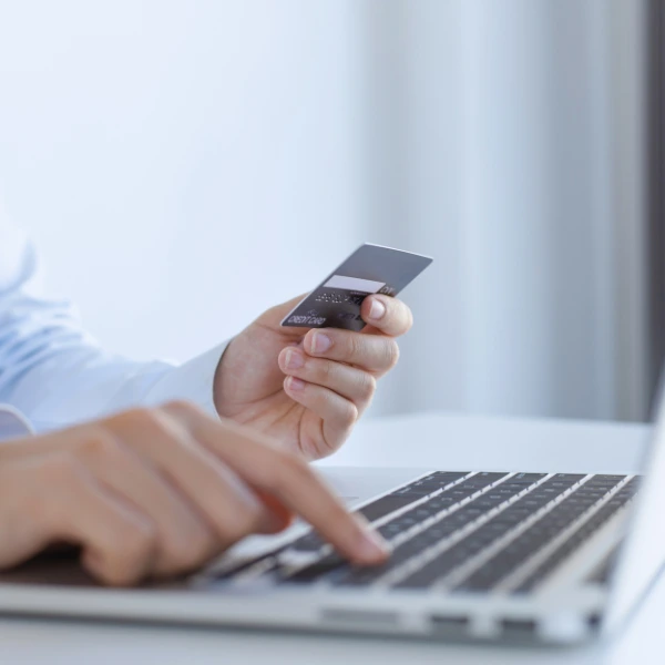 Paying for travel booking online using credit card and laptop_