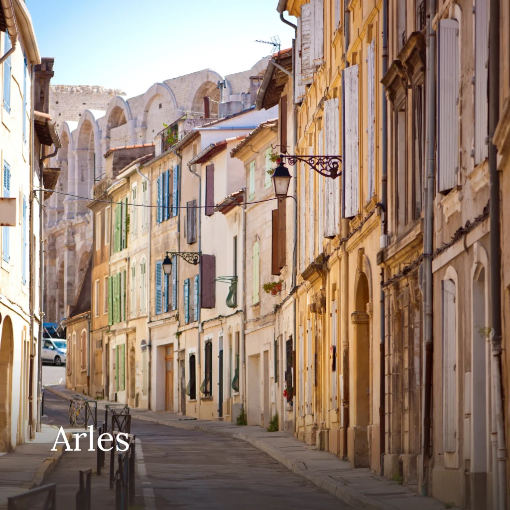Historic street in Arles with traditional Provençal buildings and Roman amphitheatre