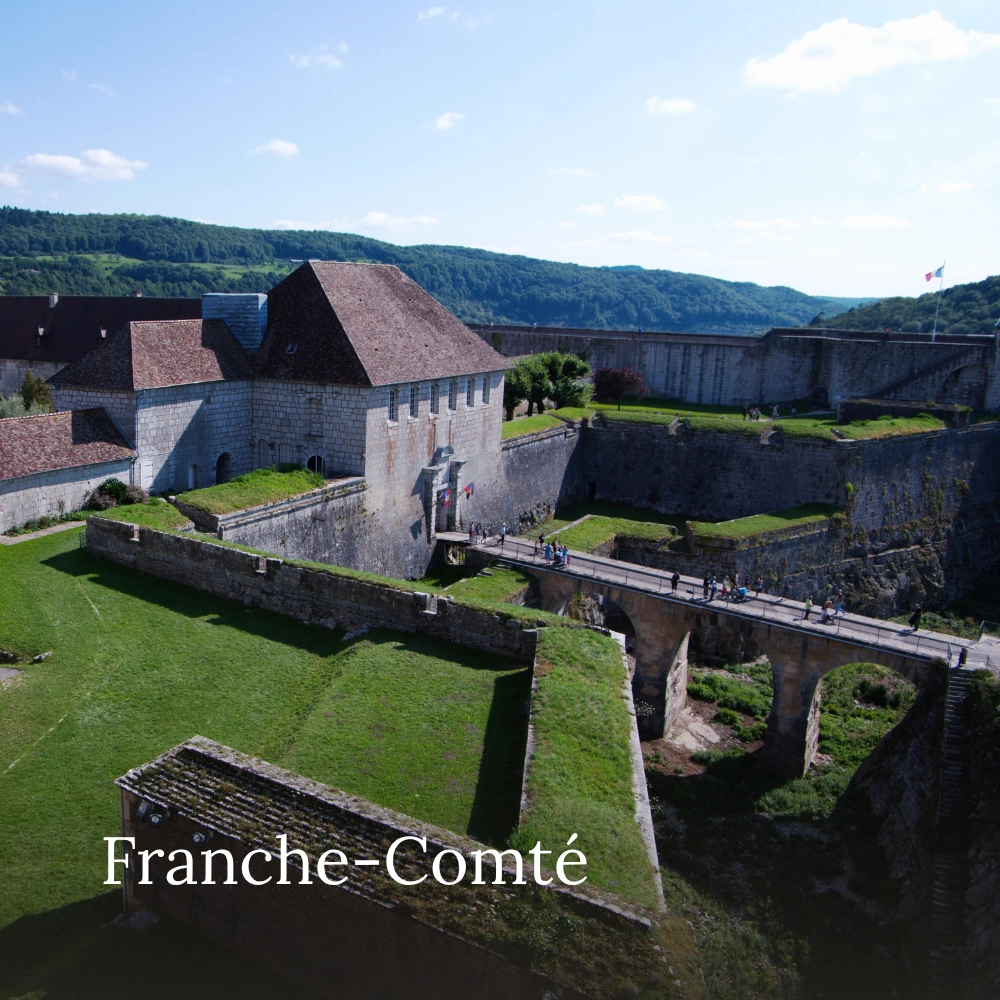 Historic Citadel of Besançon with stone fortifications and a bridge, surrounded by green hills in Franche-Comté, France